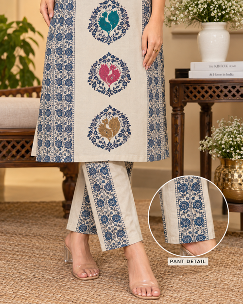 Beige printed kurta with red side panels and traditional peacock design