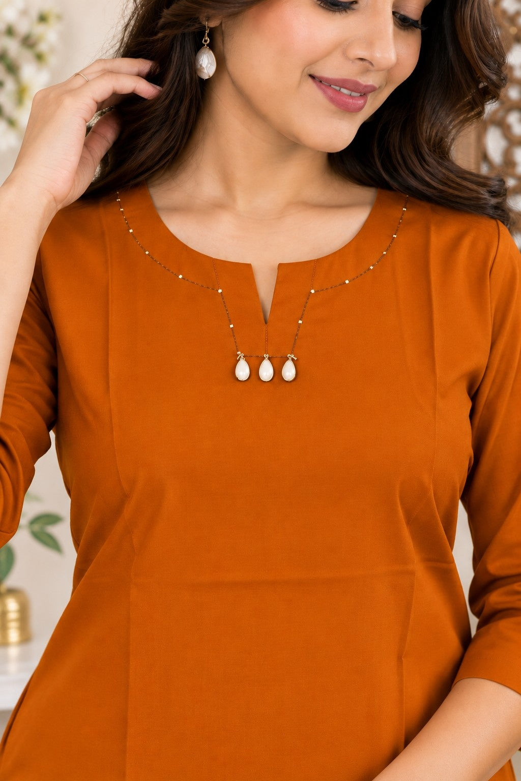 Rust orange straight kurti with round neck and delicate embellishment